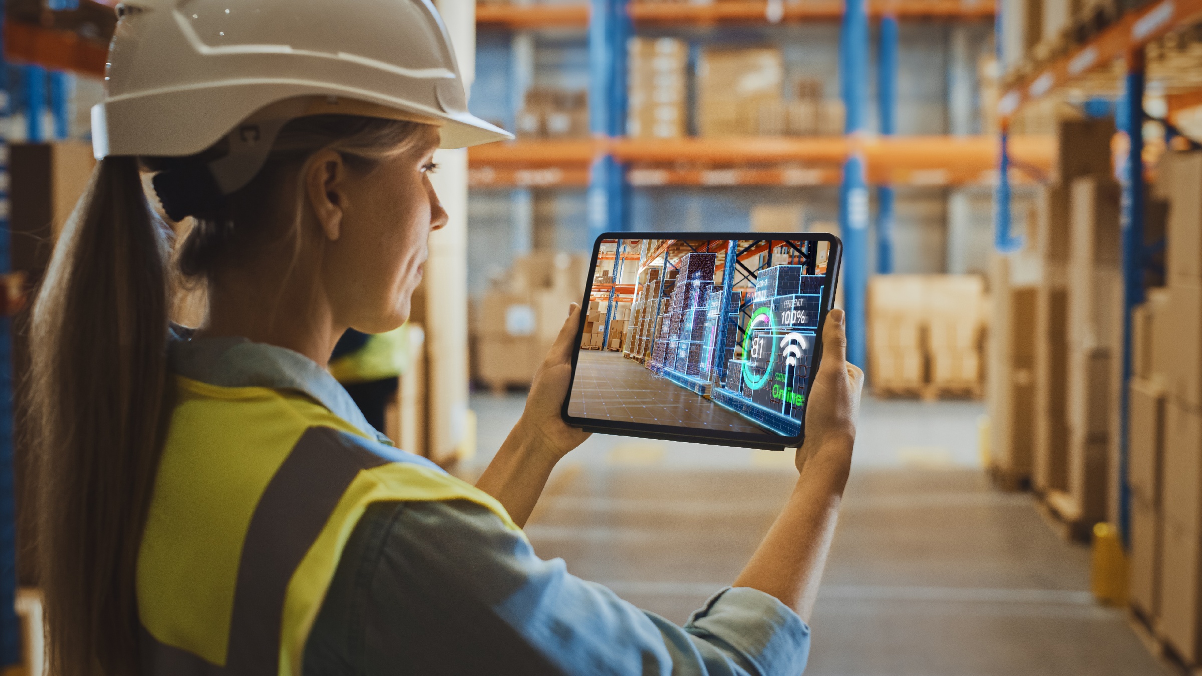 Kvinde bruger digital twin supply chain warehouse reality-applikation på en tablet.